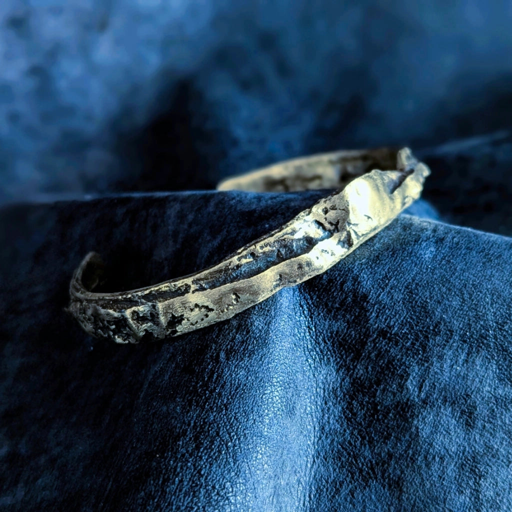 Découvrez le jonc en laiton massif à la patine noire organique. Un bracelet texturé à la main en Corse, mêlant reflets dorés et profondeur sombre. Design unique.